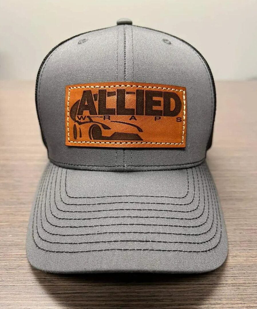 A gray hat with an leather patch on it.